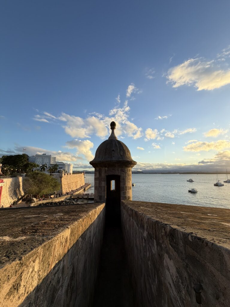 Historic garita overlooking the water and sailboats at sunset in Old San Juan