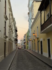 Cobblestone street lined with colorful buildings in Old San Juan at golden hour