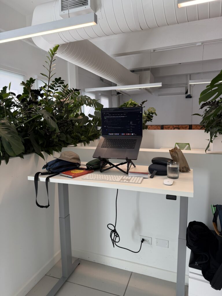 Laptop workstation surrounded by plants inside CoPiloto 151 coworking space