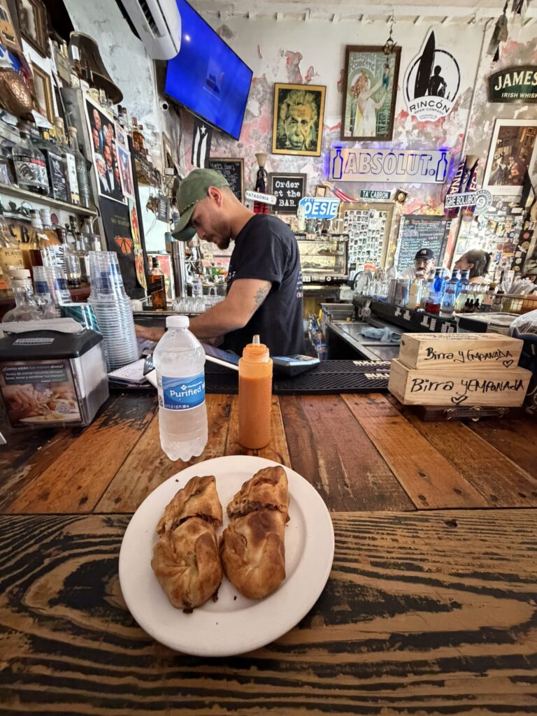 Pastrami empanadas and hot sauce served at the bar at Deshistoria